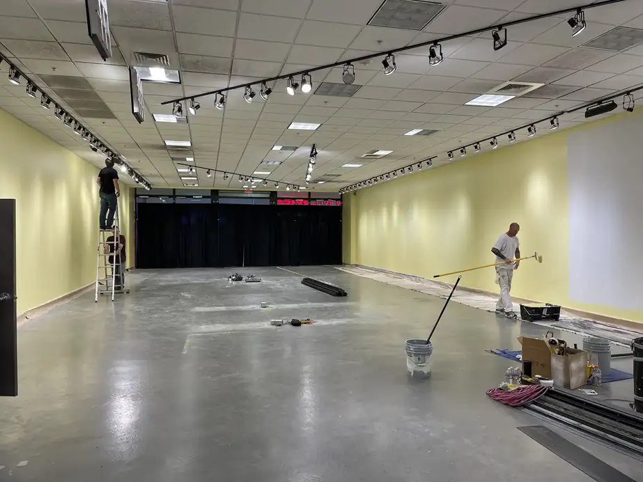 Empty retail space mid repaint with two painters working