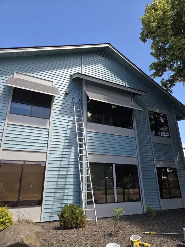 Teal two-storey building with a ladder leaning on the wall