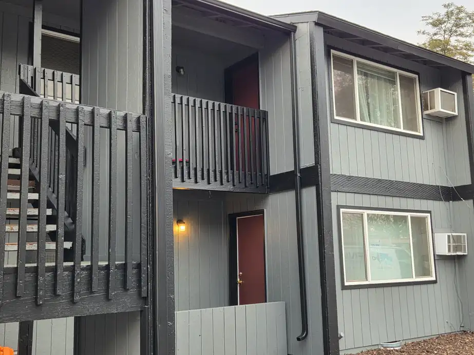 Apartment building painted grey with black stair rails and balconies