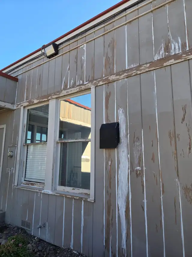 Weathered panel siding with old paint peeling away, before PNW Paint Company prepped it