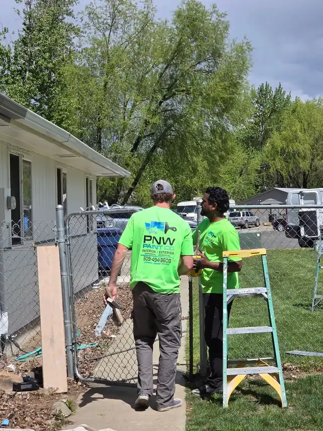 Two PNW Paint Company painters in branded safety green crew shirts